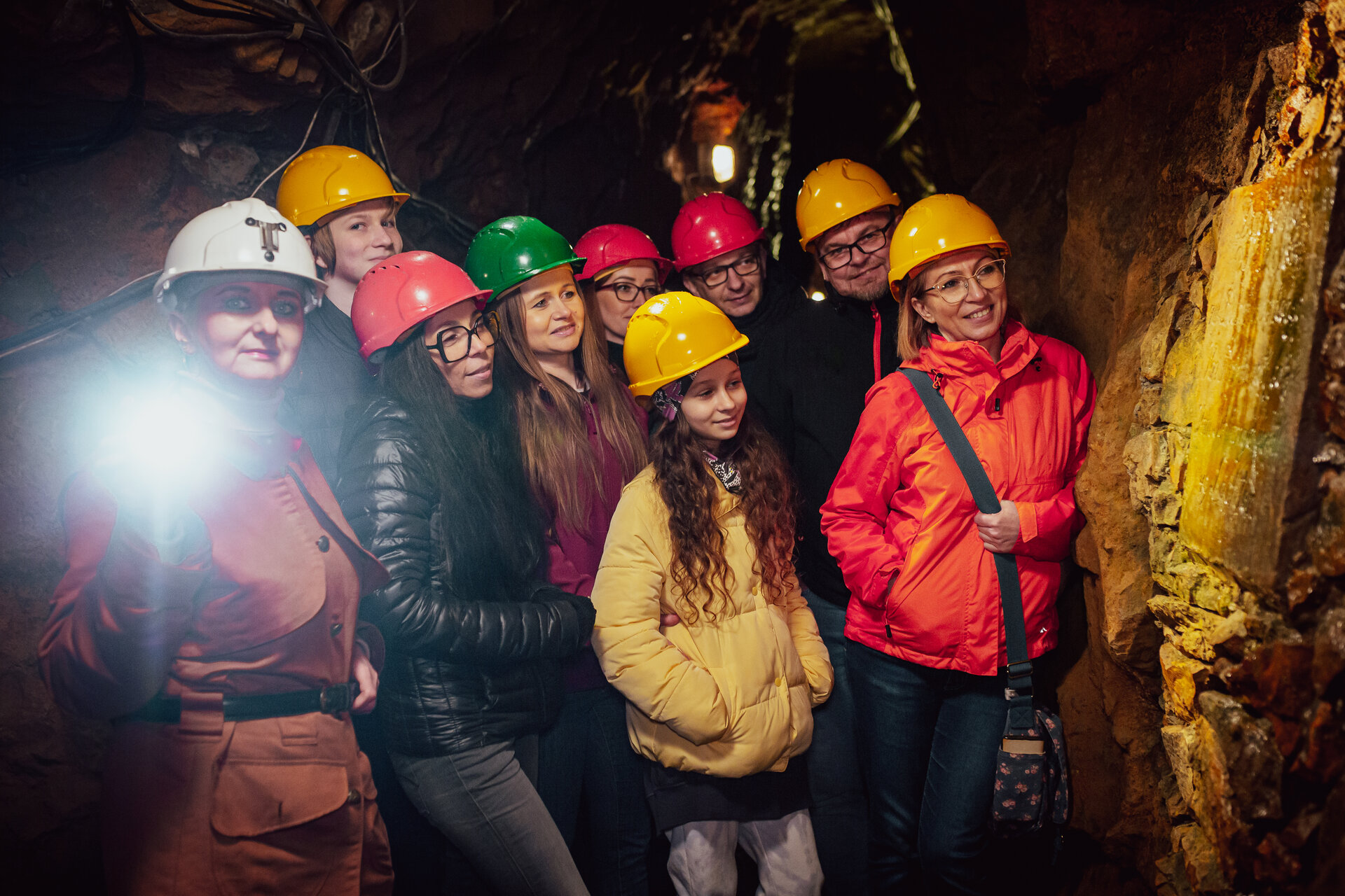 Grupa turystów z przewodnikiem w podziemiach Zabytkowej Kopani Srebra