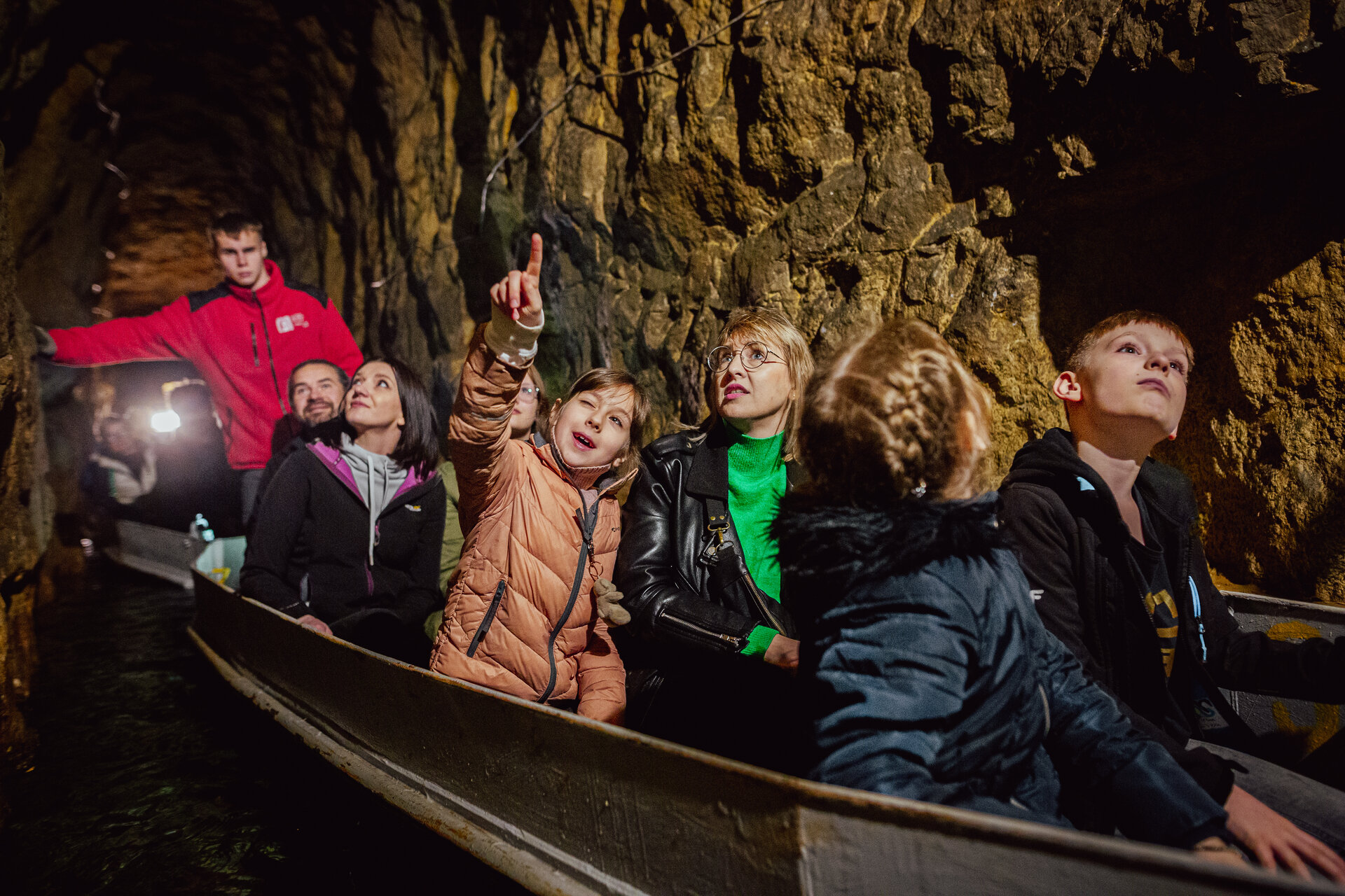 Turyści płynący łodzią w Sztolni Czarnego Pstrąga