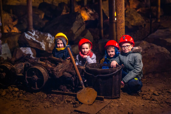 Dzieci kucające przy wózku transportowym w podziemiach