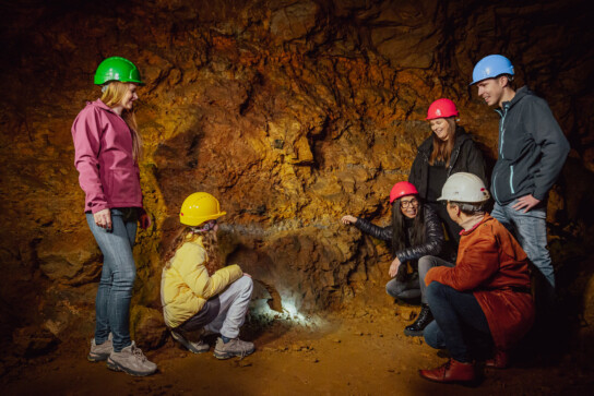 Grupa turystów z przewodnikiem w podziemiach Zabytkowej Kopalni Srebra