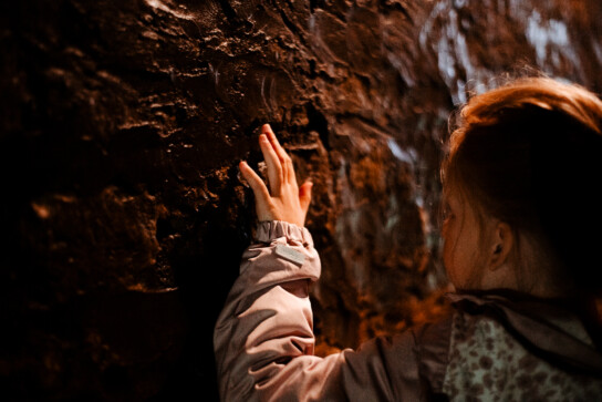 Dziewczynka dotykająca skał w podziemiach