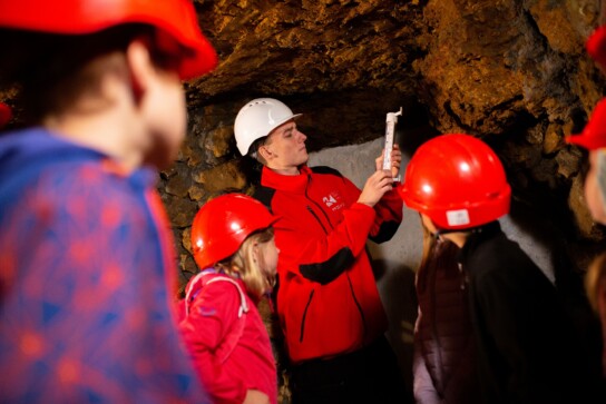 Przewodnik i grupa dzieci odczytują z termometru temperaturę powietrza