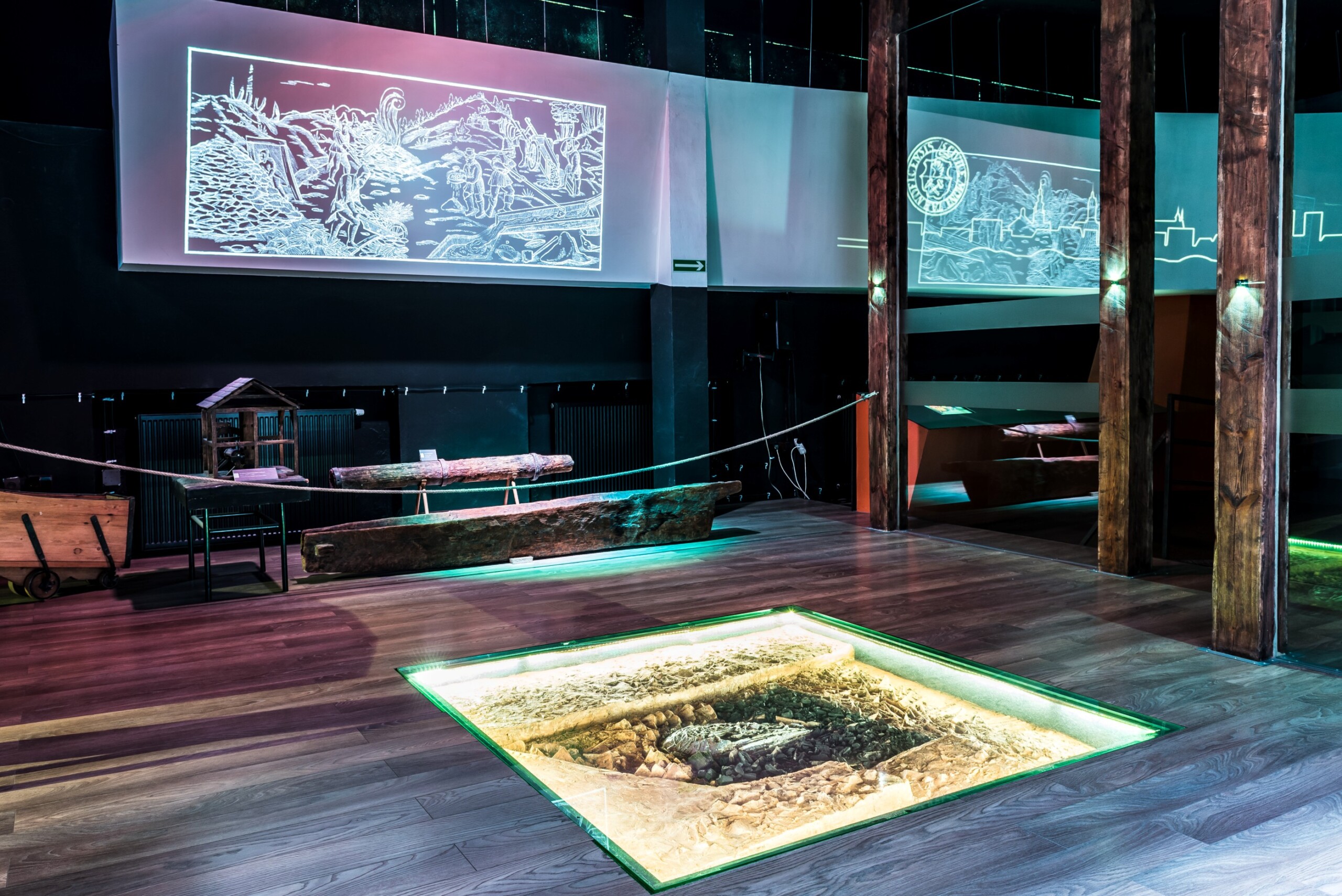 Sala muzealna z podświetlonym, przeszklonym modelem pieca w podłodze