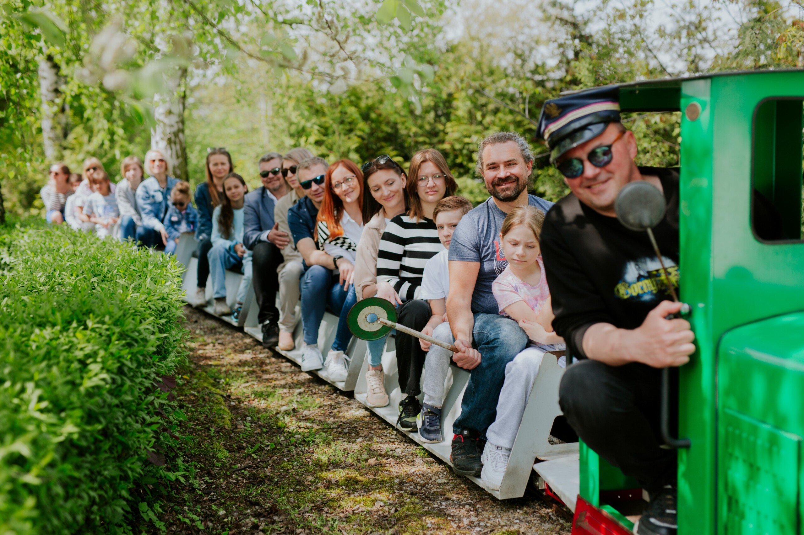 Ludzie jadący kolejką w&nbsp;Skansenie Maszyn Parowych