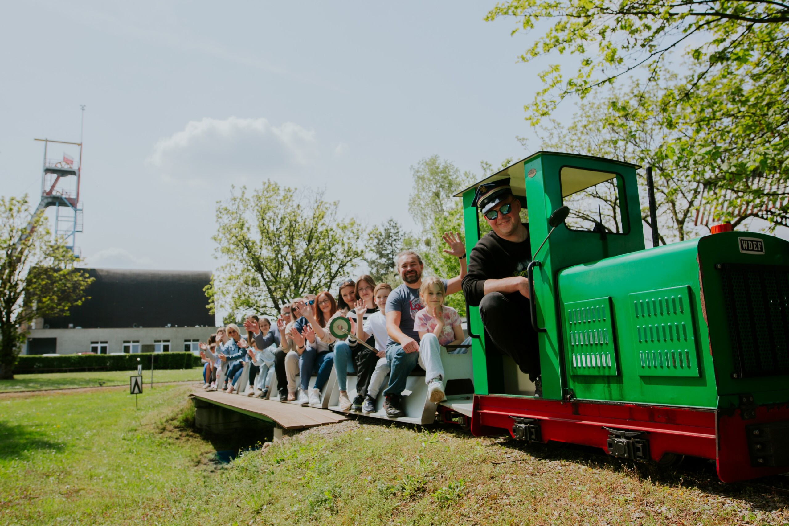 Ludzie jadący kolejką w&nbsp;Skansenie Maszyn Parowych