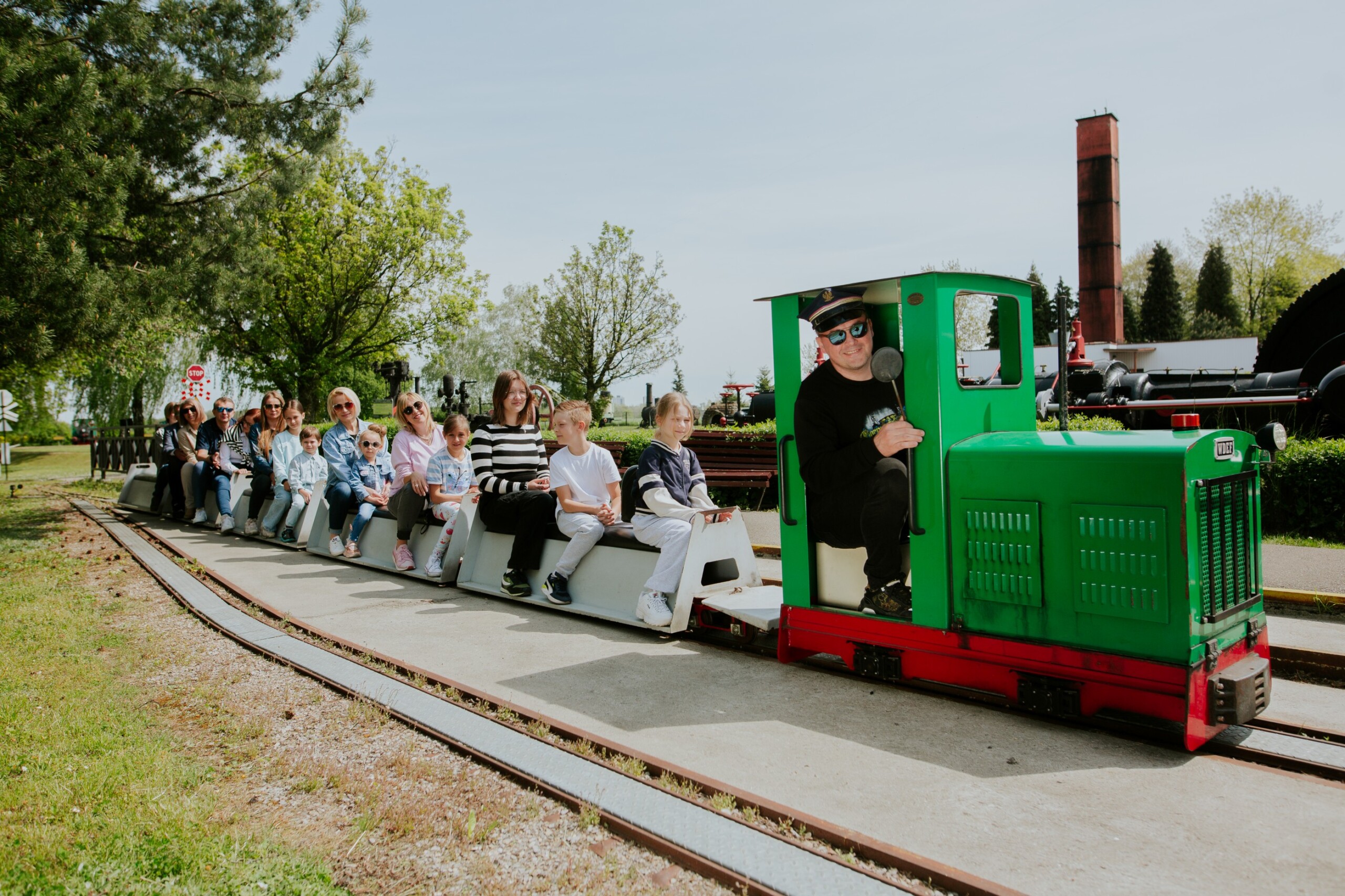Ludzie jadący kolejką w&nbsp;Skansenie Maszyn Parowych