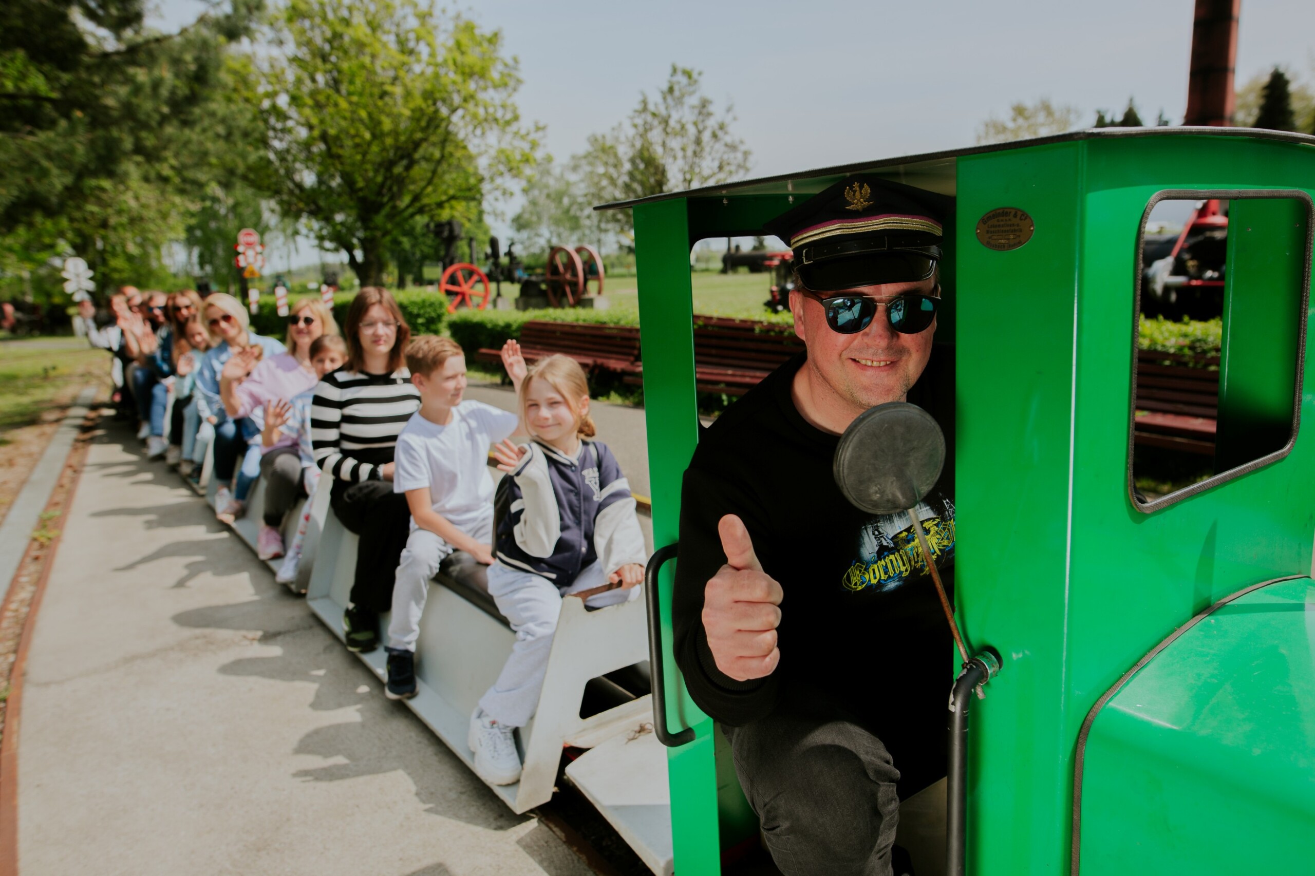 Ludzie jadący kolejką w&nbsp;Skansenie Maszyn Parowych